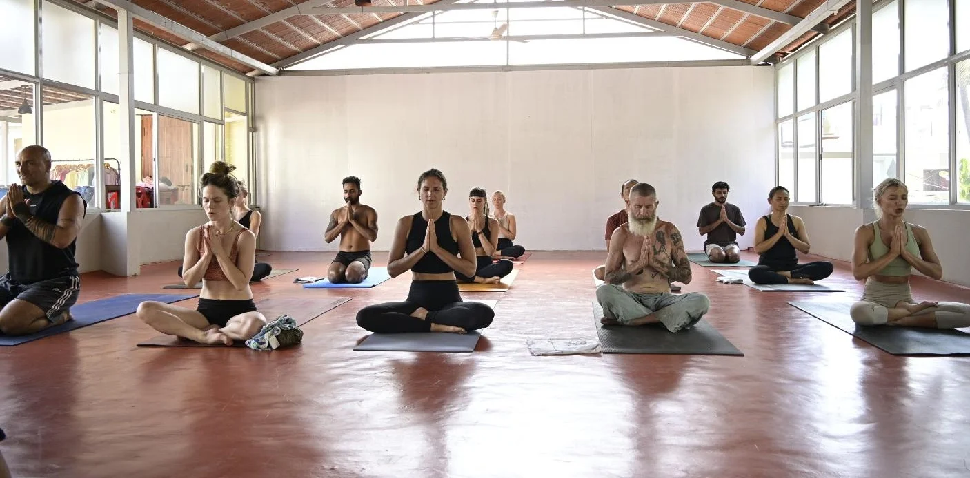 A yoga class on mats in the shala at Manasthala